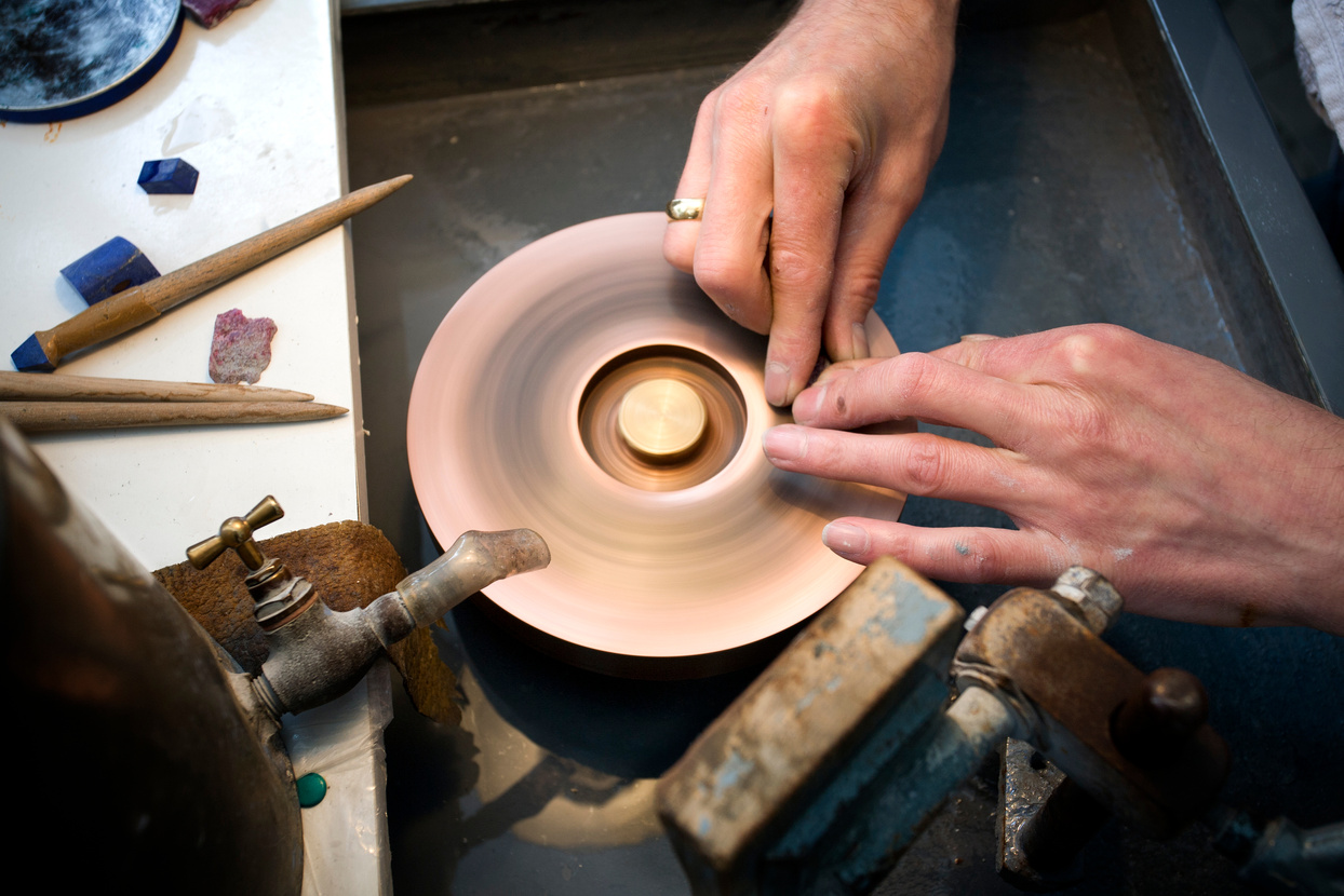 Lapidary at work on a grinding machine